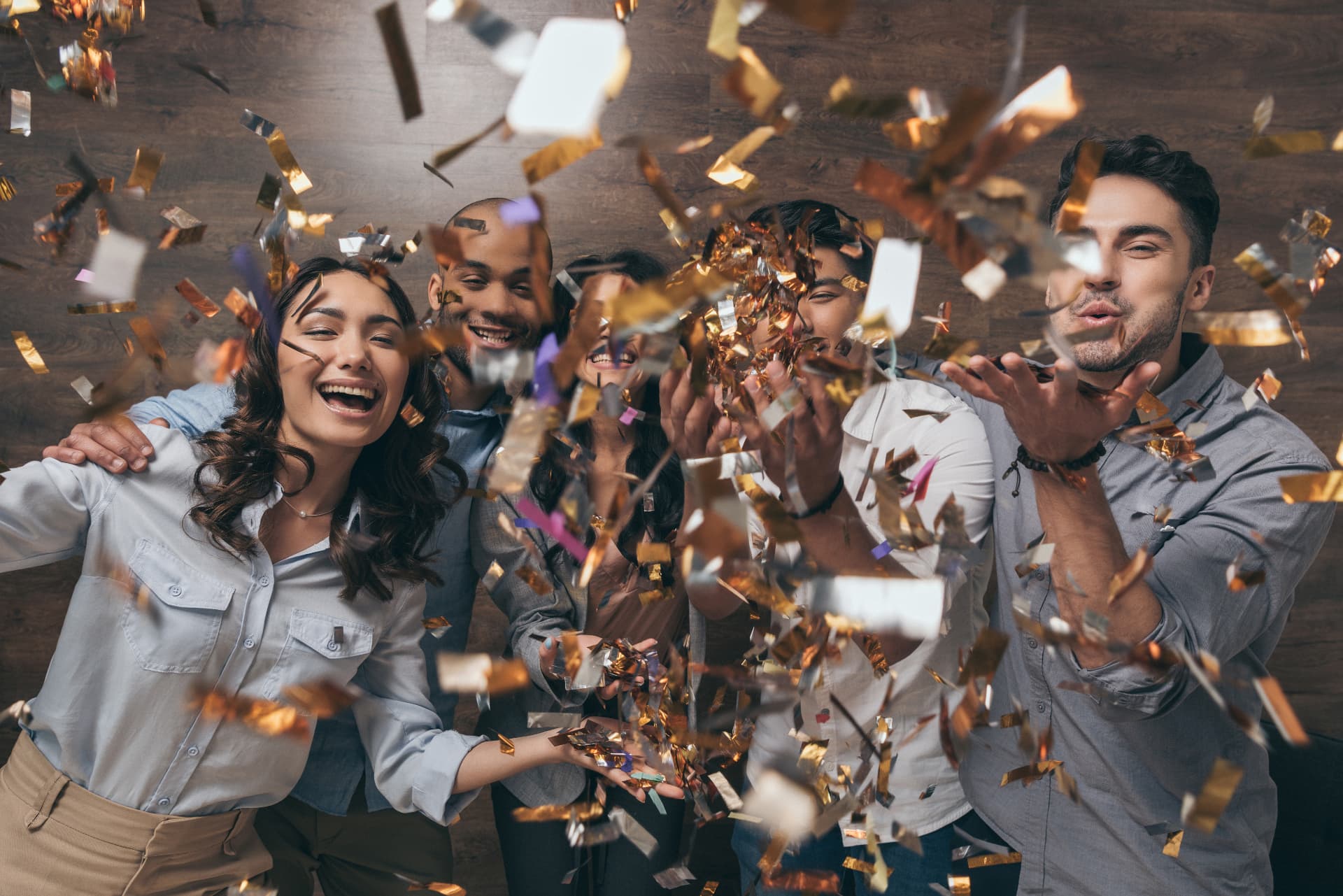 Friends celebrating together while confetti fills the air