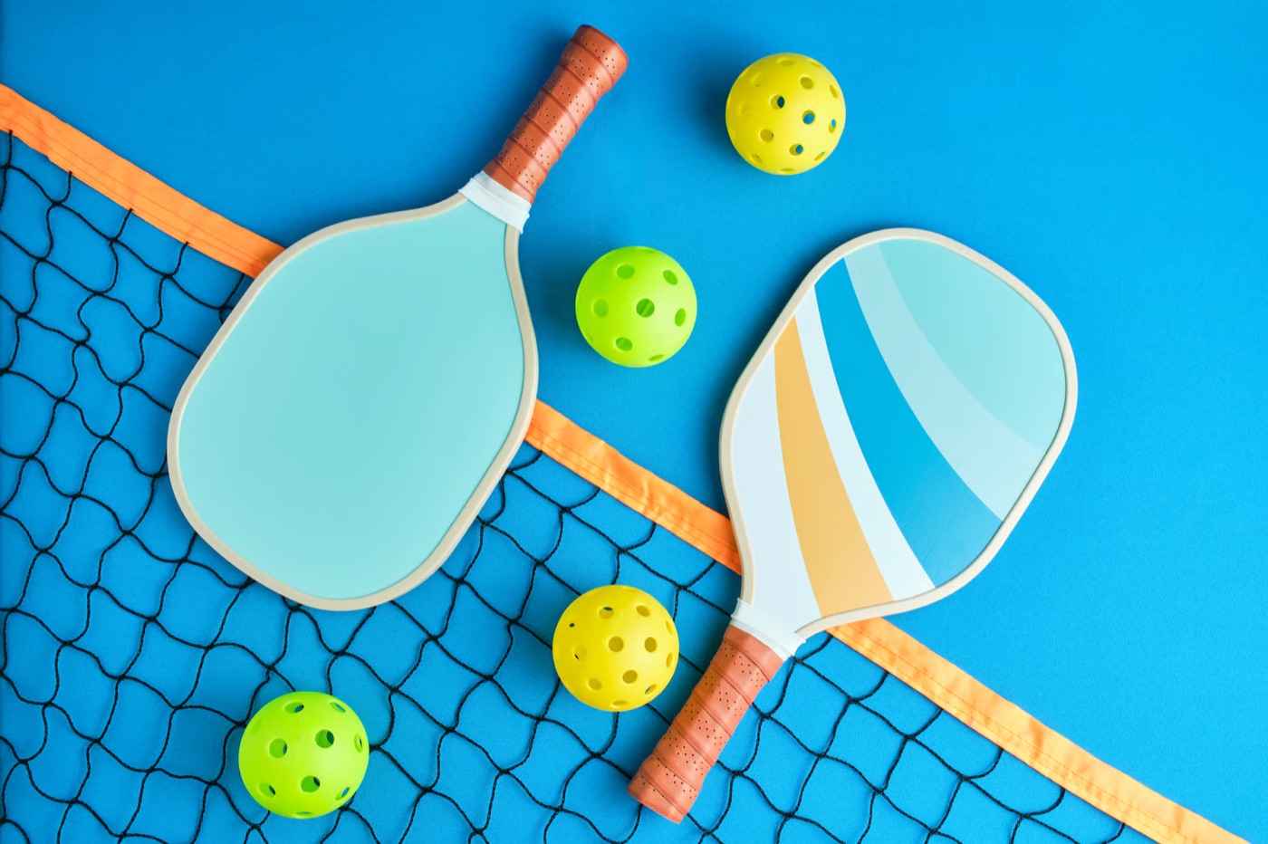 Pickleball paddles and colourful balls on a blue background