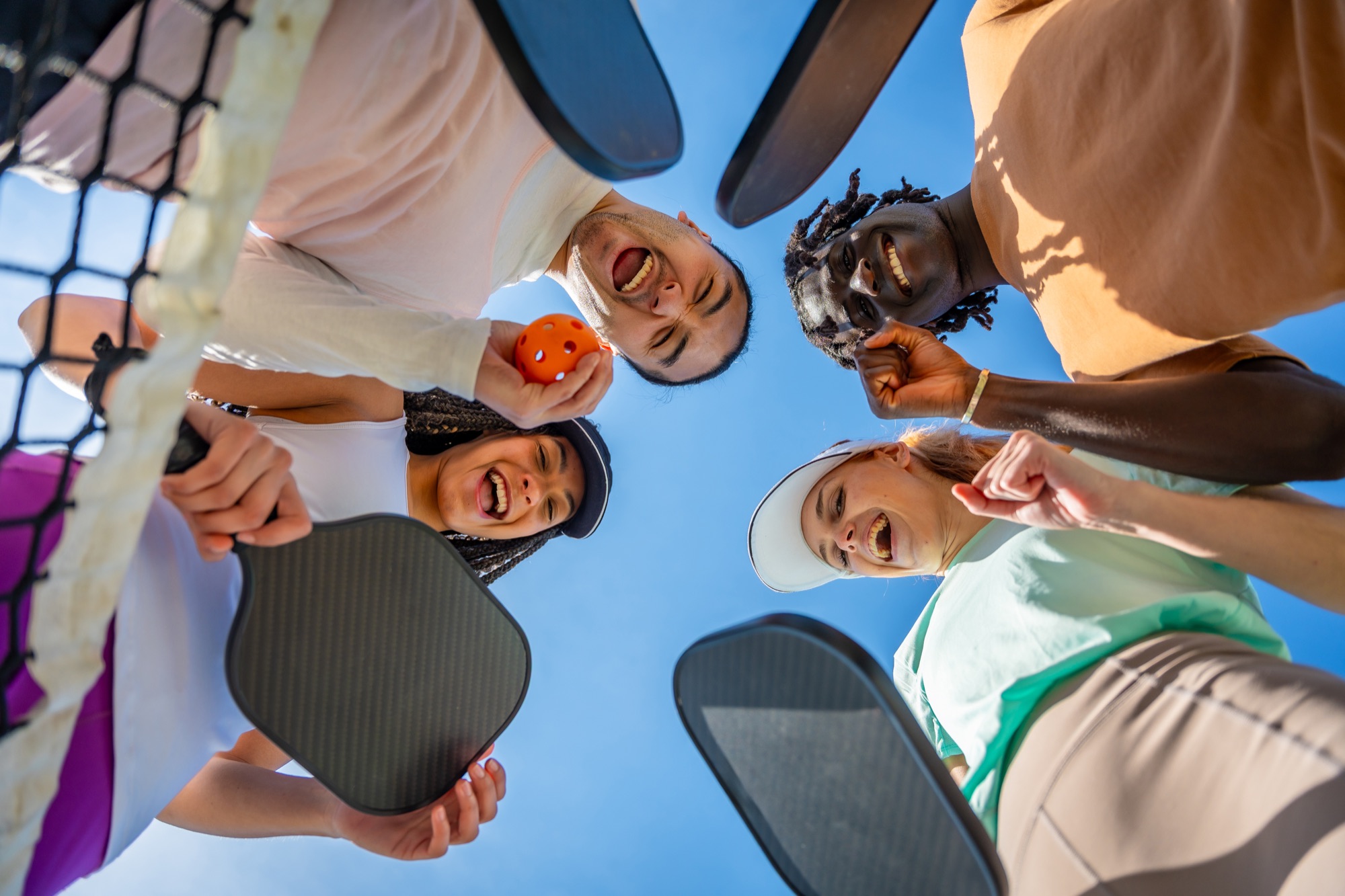 Friends celebrating together with pickleball paddles
