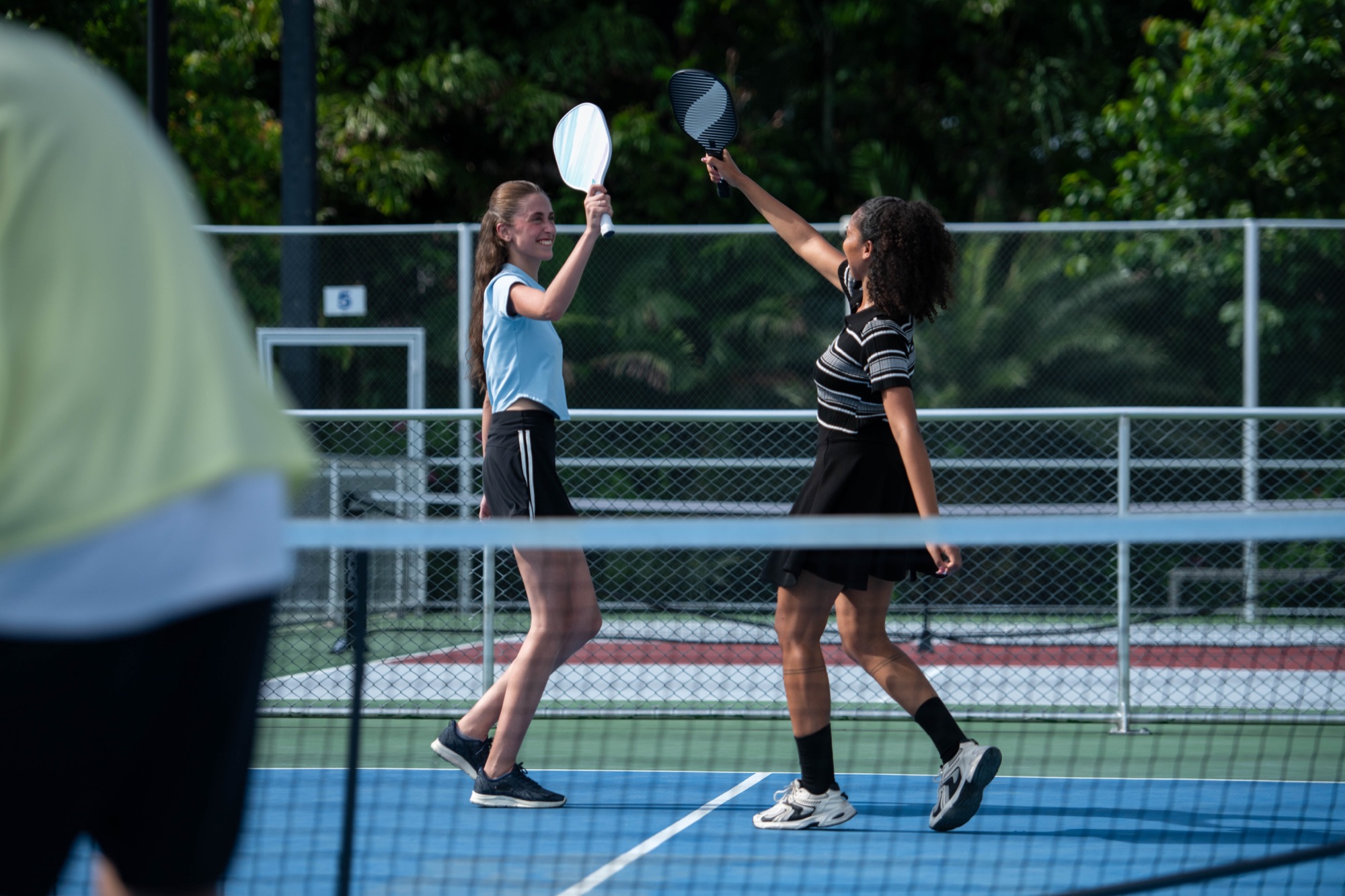 Two players celebrating a point with their paddles